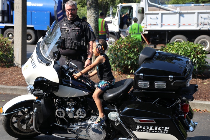 A boy sits on a SeaTac Police motorcycle